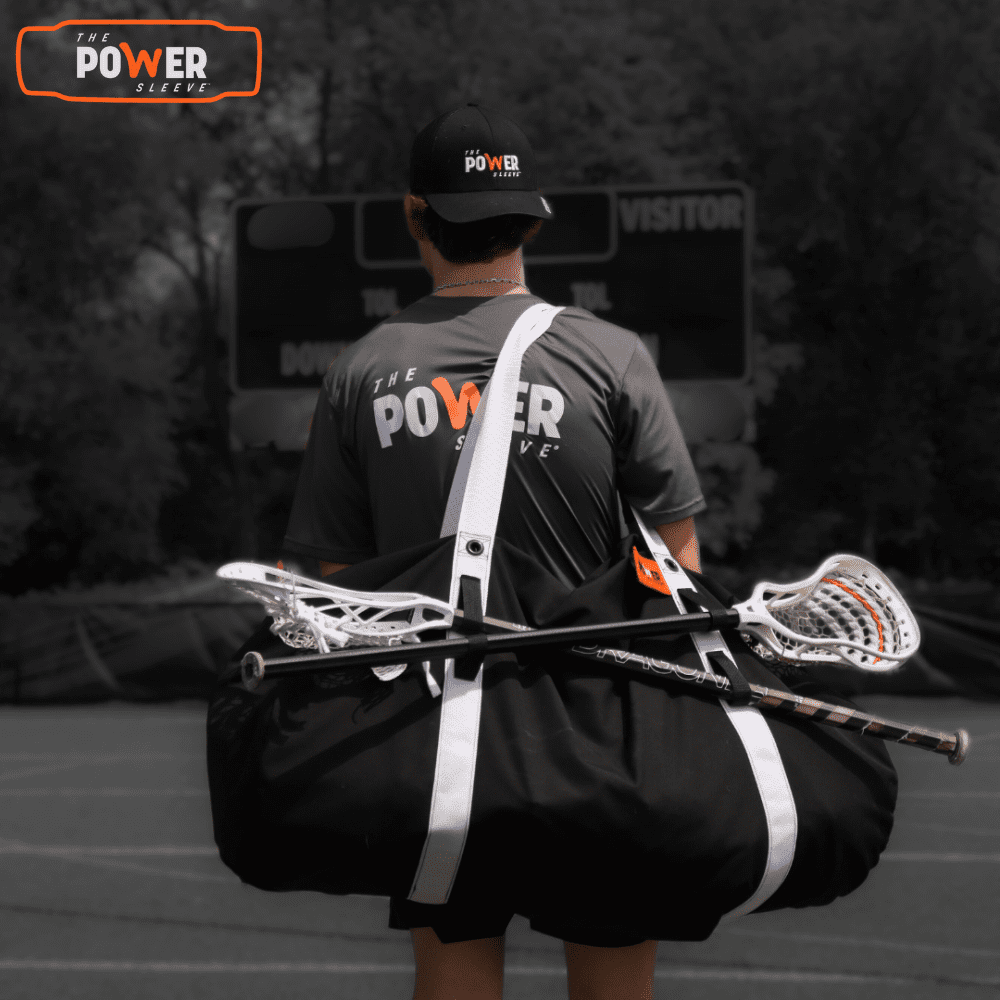 Lacrosse player carrying Power Sleeve® lacrosse bag over shoulder with sticks secured in dual stick loops — premium USA-made lacrosse bag for players.